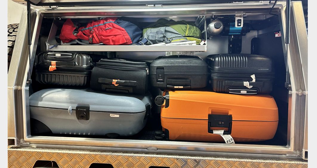 We estimate would be 3 big cases, or 2 big 2 small as the BBQ takes up space. Soft bags always preferred. Photo below shows the space with luggage without BBQ. 